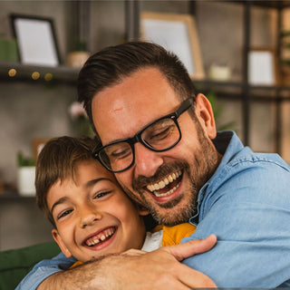 A father laughing and hugging his son, highlighting confidence and character growth through the Montessori method in Spring, TX.